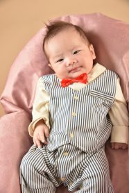 ベストに蝶ネクタイを付けた赤ちゃんの写真