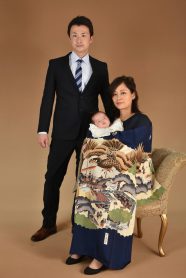 スーツのご両親と産着を着た男の子の赤ちゃん