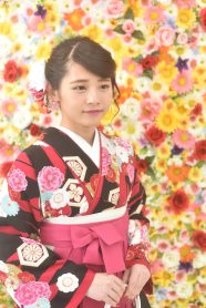 花の背景と黒×ピンクストライプの着物とピンクの袴の女の子