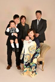 産着を着た赤ちゃんと正装をした、両親、兄、祖父母での家族写真