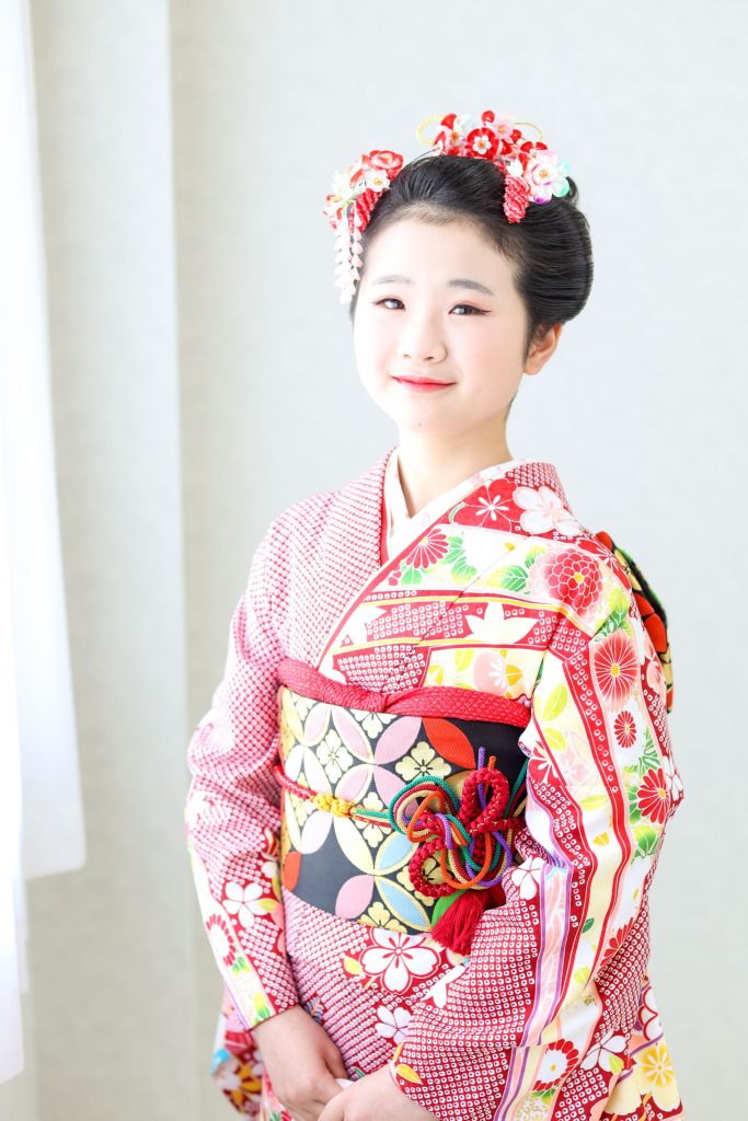 日本髪に髪を結った半田市の十三詣りに参加する女の子　赤い着物を着ている