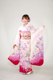 白地に濃いピンクの細かい花柄振袖で笑顔の女の子
